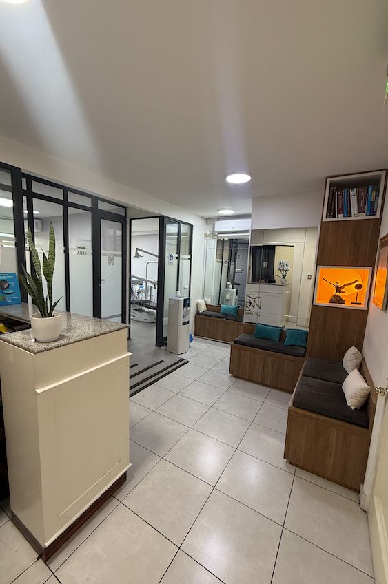 Sala de espera de la clínica con sofás y boxes acristalados