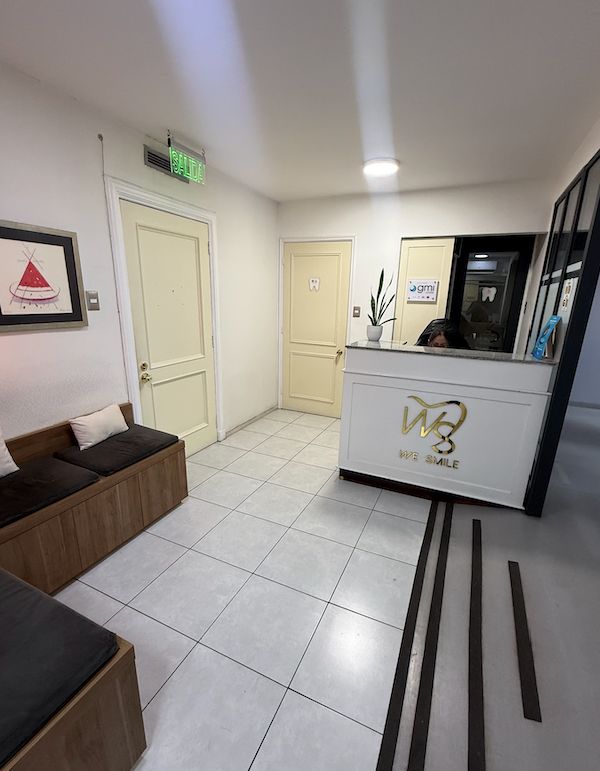 Recepción principal de Clínica Dental Wesmile con logo dorado